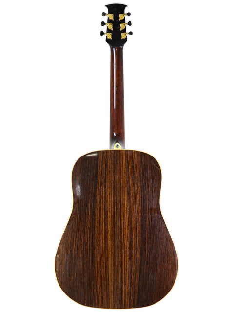 The back of a Jim Williams acoustic guitar, featuring a smooth wooden surface, labeled "WD-40 - Australia 2005."