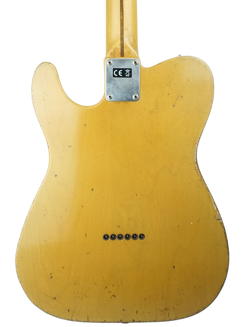 The back of a bright yellow 50s Stratocaster guitar by Nacho Guitars, highlighted by a stylish black pickguard.
