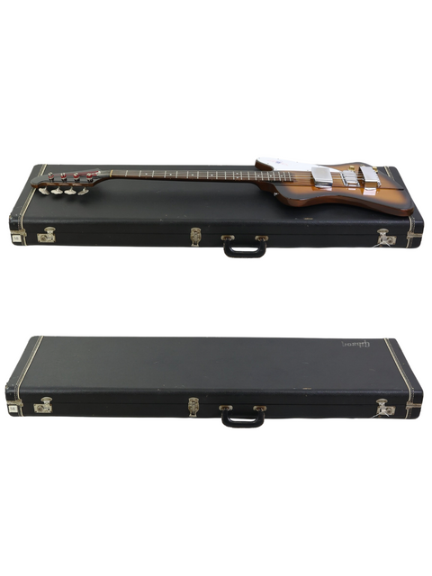 Two guitar cases support a vintage 1976 Gibson Bicentennial Thunderbird IV Bass, emphasizing its timeless appeal and heritage.