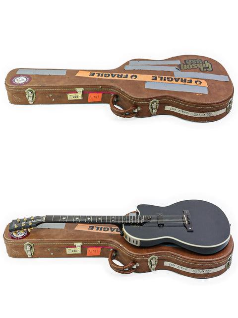 Two guitars housed in a case, displaying a label on the back that states "Gibson Chet Atkins SST - USA 2001."