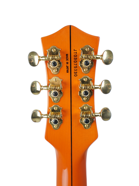 Vibrant orange guitar headstock adorned with elegant gold hardware, a must-have for guitar lovers. Gretsch Roundup 6121W Reissue, Japan 2003.