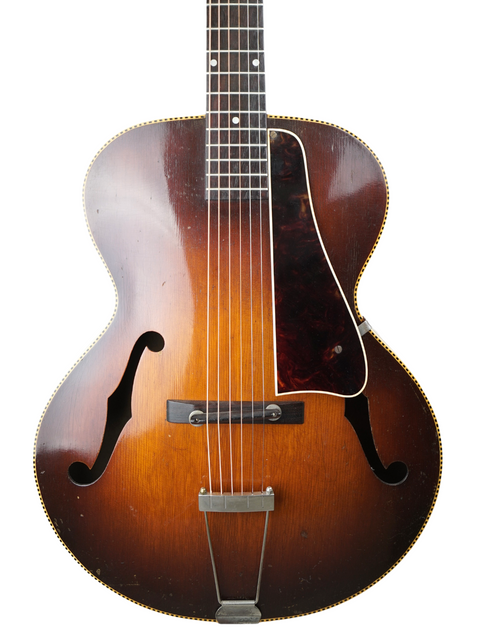 Vintage 1951 Gibson J-45 sunburst guitar, showcasing its classic design and rich tones, alongside a 1938 Kalamazoo KG-32.

