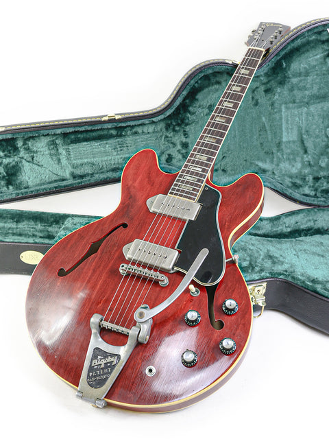Vintage 1965 Gibson ES-330 guitar in red, positioned in its case on the floor.