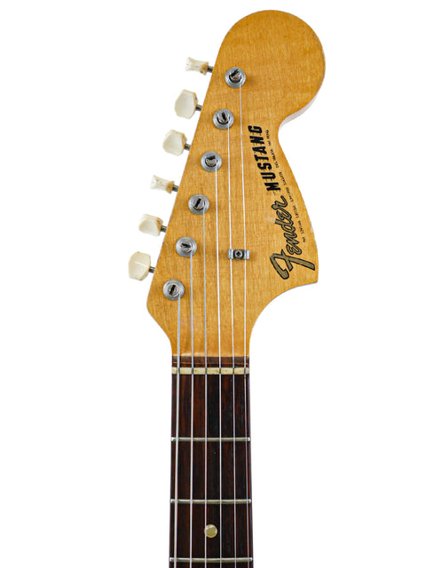  Vintage 1967 Fender Mustang guitar set against a white backdrop, emphasizing its timeless style and rich musical heritage.
