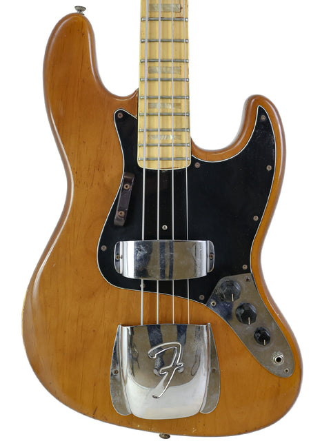 Vintage 1974 Fender Jazz Bass guitar, complete with a black pick guard, representing timeless style and musical heritage.
