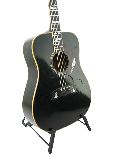 Vintage 1977 Gibson Dove Custom acoustic guitar in black, beautifully showcased on a stand, ready to play.