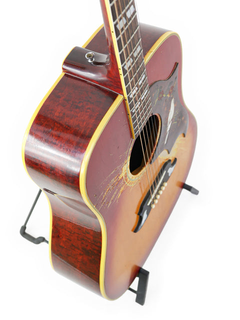 Vintage Gibson Dove guitar from 1968, featuring a wooden body and displayed on a wooden stand.