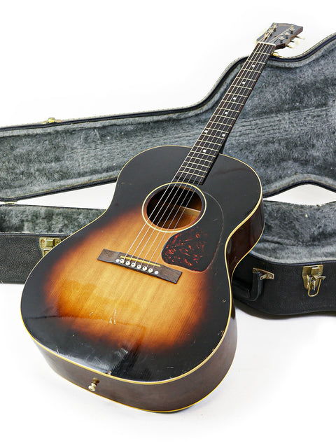 Vintage Gibson LG-1 guitar from 1954 displayed in its protective case, emphasizing its timeless style.