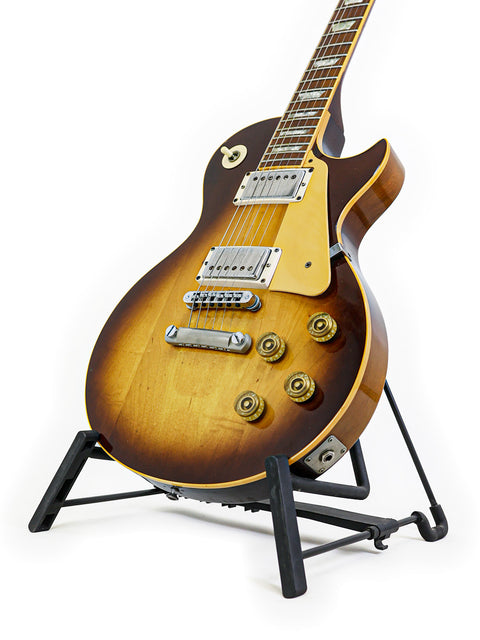 Vintage Gibson Les Paul Standard from 1979 showcased on a stand, set against a pristine white background.