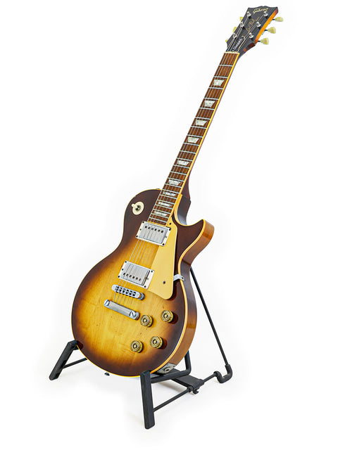 Vintage Gibson Les Paul Standard from 1979 showcased on a stand, set against a simple white background.