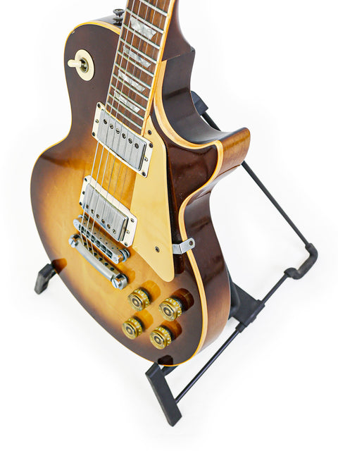Vintage Gibson Les Paul Standard guitar from 1979, elegantly positioned on a stand with a white background.