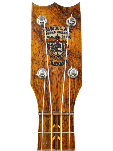 Vintage Kumalae ukulele from the 1920s, showcasing a wooden head and neck, embodying the spirit of Hawaiian music.
