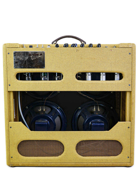 Vintage yellow guitar amplifier with exposed speakers and worn faceplate on a white background.