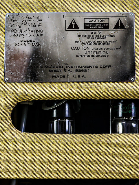 Warning label on electronic equipment with visible parts through a vented casing.