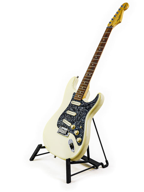 White Fender Jeff Beck Signature Stratocaster guitar displayed on a black base stand, highlighting its classic style.