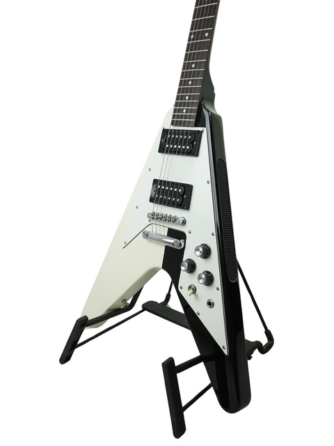 White flying V electric guitar on a black stand against a white background.