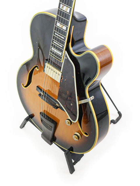 classic 1982 Ibanez JP20 Joe Pass Signature guitar is prominently featured on a stand, emphasizing its iconic style and heritage.