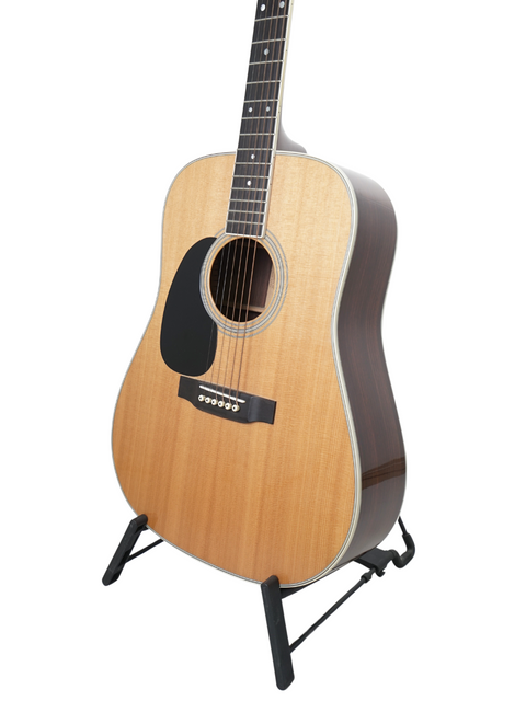 left-handed Martin D-35 guitar displayed on a stand, set against a bright white backdrop, highlighting its beautiful finish.

