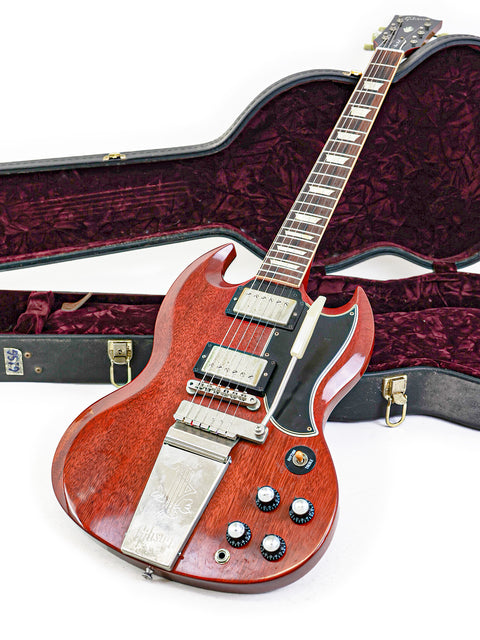 vibrant red Gibson Custom Les Paul SG Standard M VOS guitar with its case, displayed on a white background.

