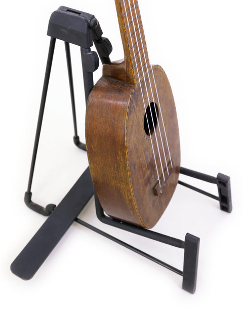 1930 Kamaka Pineapple Ukulele, a vintage piece from Hawaii, sitting gracefully on a stand.