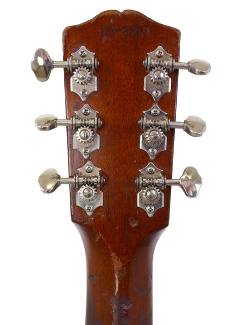 1930s Gibson D-18B acoustic guitar, highlighting its elegant curves and rich wood finish, a true vintage instrument.