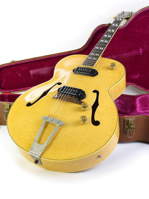 1952 Gibson ES-300 guitar in yellow with a protective case, showcased on a white backdrop.