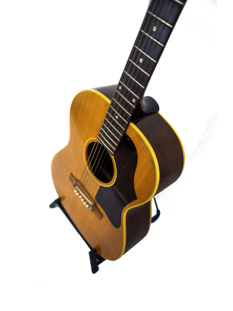 1962 Gibson LG-3 Acoustic guitar resting on a stand, set against a plain white background.