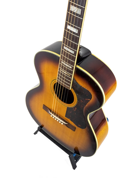 1962 Guild F-40 Valencia guitar on a stand, showcased with a simple white background.