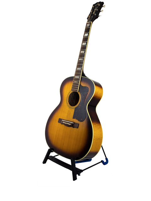 1962 Guild F-40 Valencia guitar showcased on a stand, featuring a stark white background.