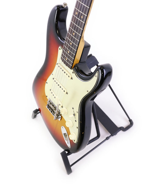 1964 Fender L Series Stratocaster guitar on a stand, featuring a stark white background for a clean look.
