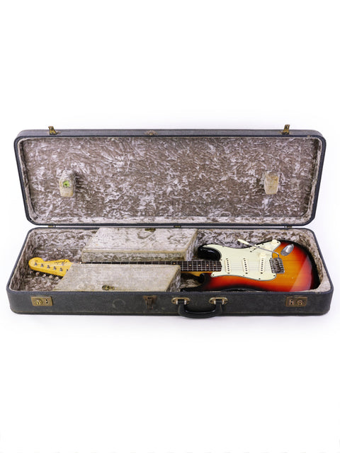 1964 Fender Stratocaster electric guitar in a case, showcasing its vintage appeal and a beautiful refinished surface.