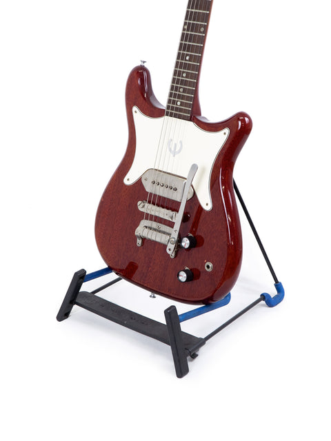 1965 Epiphone Coronet guitar displayed on a blue stand, showcasing its vintage design and craftsmanship.