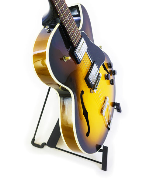 2001 Gibson ES-135 guitar displayed on a stand with a simple white backdrop.