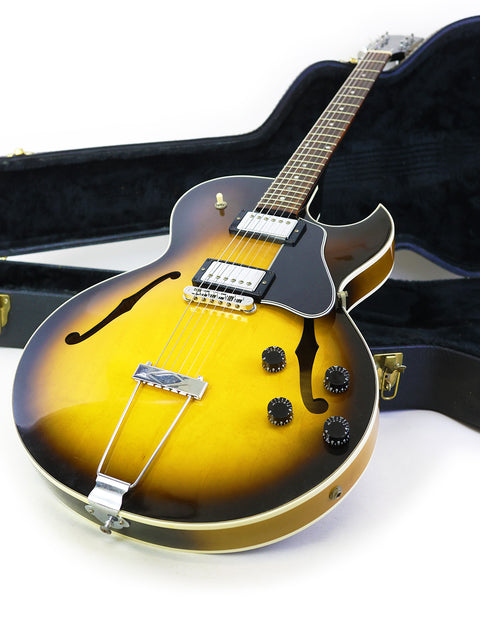 2001 Gibson ES-135 guitar resting in its case, set on a bright white background.