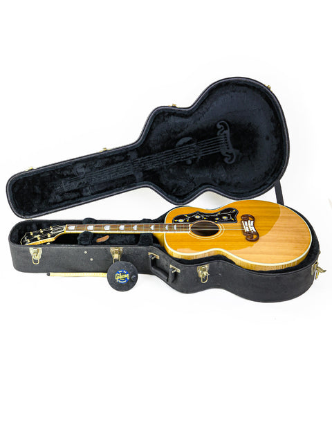 2001 Gibson SJ-200 guitar securely placed in a case, set against a pristine white backdrop, highlighting its craftsmanship.