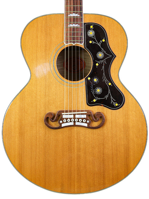 2001 Gibson SJ-200 guitar showcasing a wooden body with an intricate flower design.
