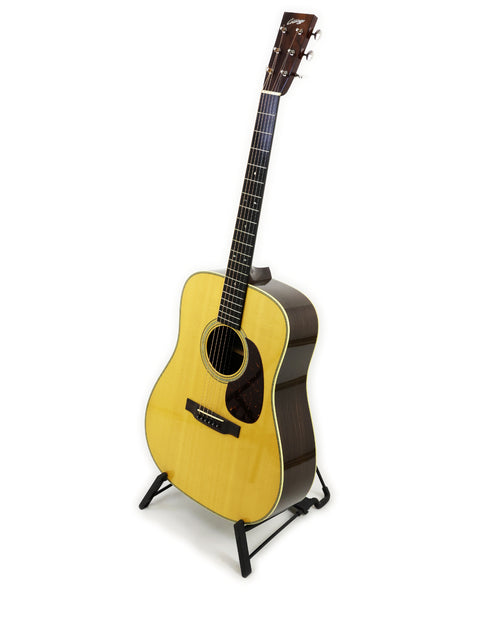 2006 Collings D2H guitar elegantly positioned on a stand with a bright white backdrop.