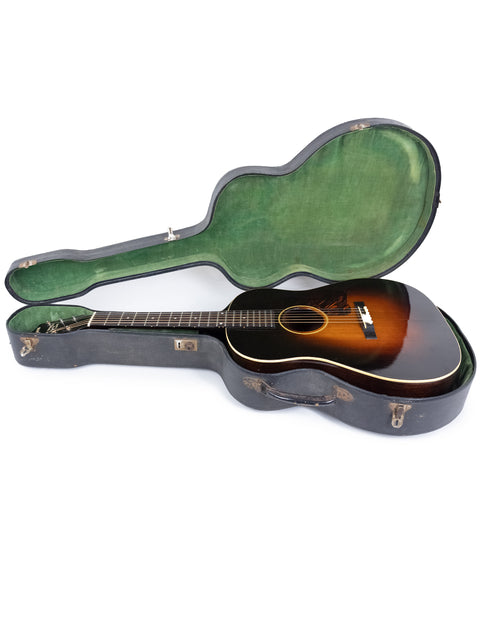 A 1935 Vintage Gibson Roy Smeck Stage De Luxe guitar resting in its case on a white backdrop.