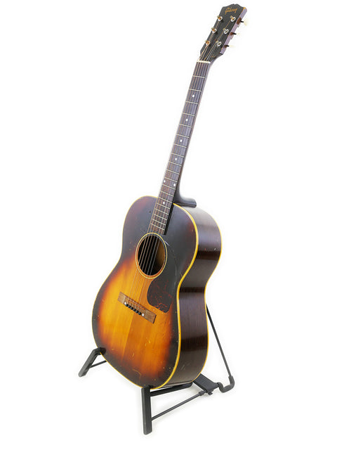 A 1954 vintage Gibson LG-2 acoustic guitar elegantly resting on a stand, highlighting its timeless beauty.