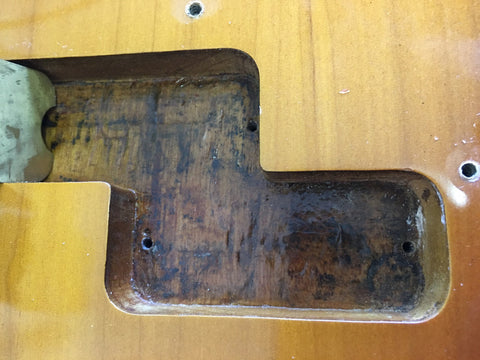 A 1958/59 Fender Precision Bass guitar showcasing a distinctive hole in the center of its body.
