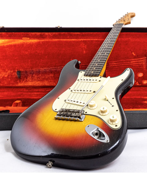 A 1964 Fender Stratocaster with a sunburst finish, exemplifying vintage craftsmanship and iconic American guitar design.
