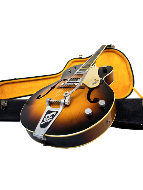 A 1964 Gretsch Double Anniversary 6117 guitar with its case, displayed on a white background.