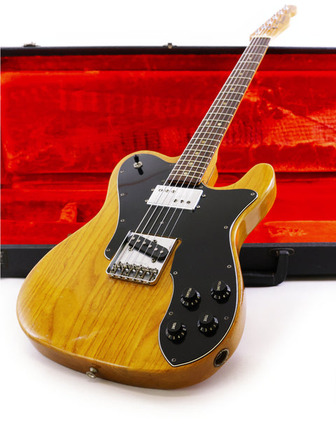 A 1977 Fender Telecaster Custom guitar featuring a wooden body, elegantly housed in a black case for protection.