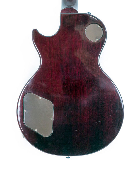 A 1991 Gibson Les Paul Standard guitar featuring a dark red body and a sleek black pickguard, highlighting its vintage appeal.
