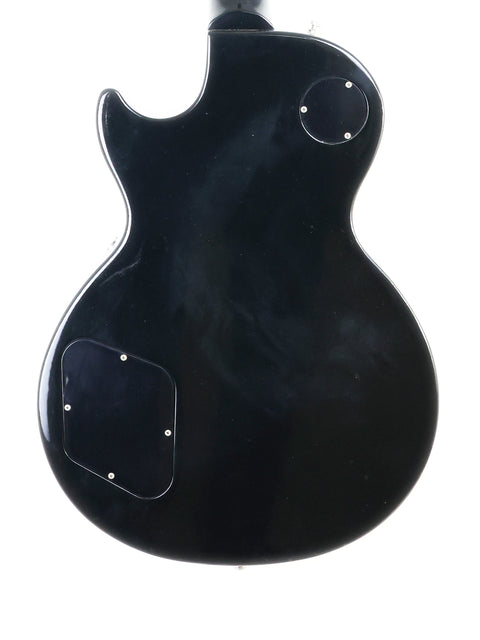 A 1995 Gibson Les Paul Standard electric guitar in black, prominently displayed on a white background, highlighting its elegant shape.