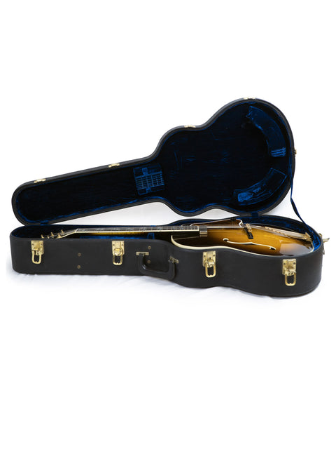 A 1997 Gibson Custom Shop Le Grand Archtop guitar is securely placed inside a protective case, ready for transport.
