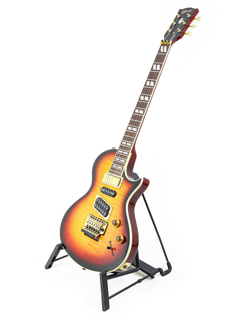 A 1997 Gibson Nighthawk guitar with a striking sunburst finish, elegantly positioned on a stand.