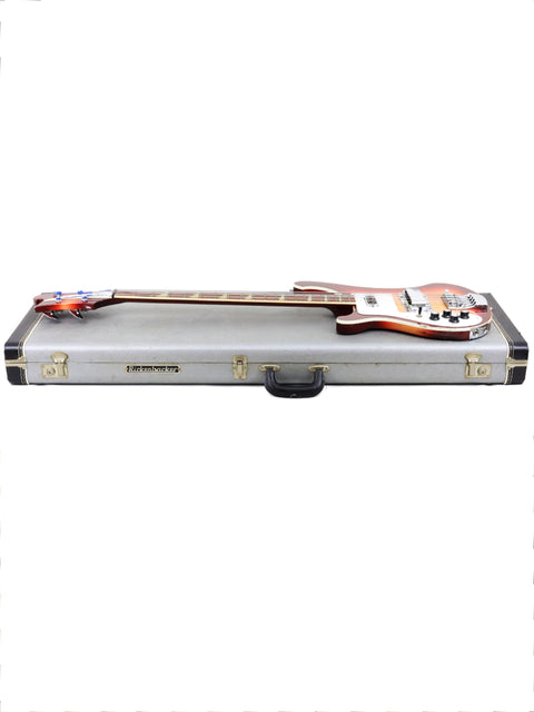 A 1997 Rickenbacker 4003 Fireglo bass guitar securely housed in a case, with a white backdrop.