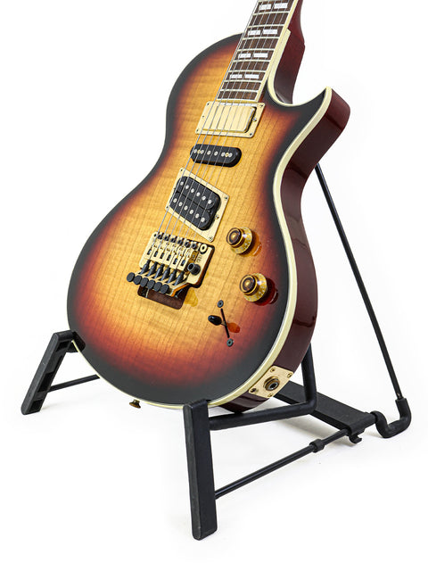 A 1997 USA Gibson Nighthawk guitar resting on a stand, set against a bright white backdrop.