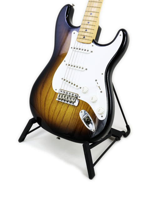 A 2004 Fender Custom Shop ‘54 Stratocaster guitar showcased on a stand with a bright white background.